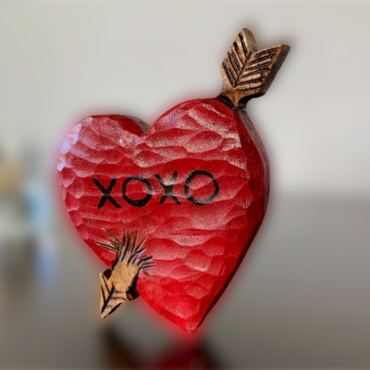 Picture of heart carving with cupids arrow sitting on a table