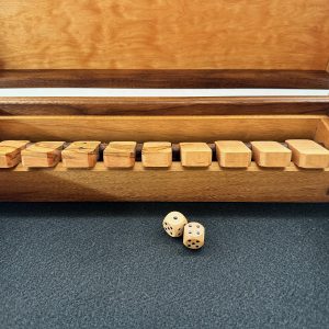 Close view of flipped wooden game tiles and dice inside the handcrafted Shut the Box game