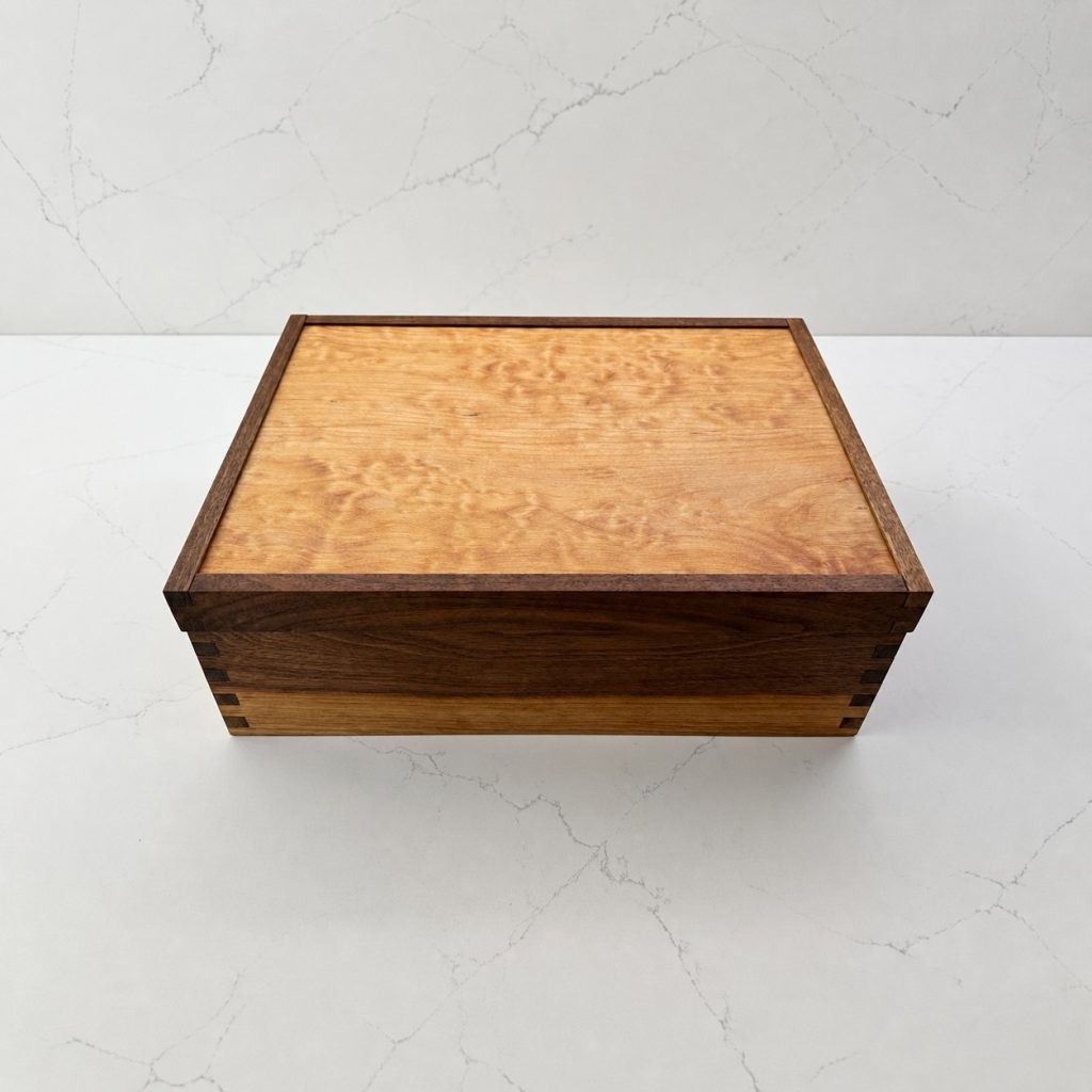 Closed handcrafted Shut the Box game with a figured maple lid and dark walnut frame