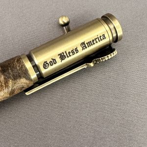 Close-up of the God Bless America engraving and eagle clip on the Liberty Burl pen