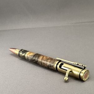 Angled view of Liberty Burl showing its antique-brass bolt-action mechanism and buckeye burl body