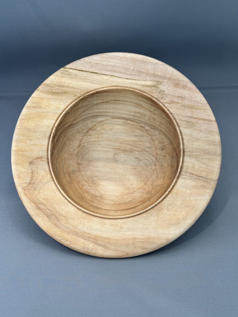 Shallow maple bowl titled Quiet Center, viewed from above