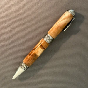 Opposite side of the maple pickleball pen, showing flowing golden grain and darker markings along the lower barrel.