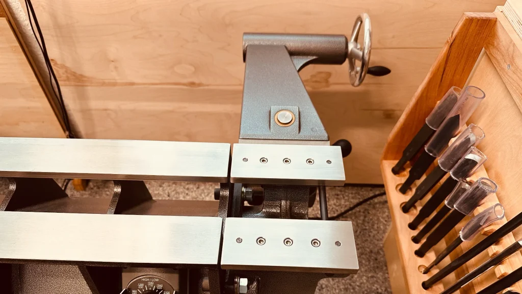 American Beauty lathe with the tailstock tilted behind the bed beside a cabinet of turning tools.