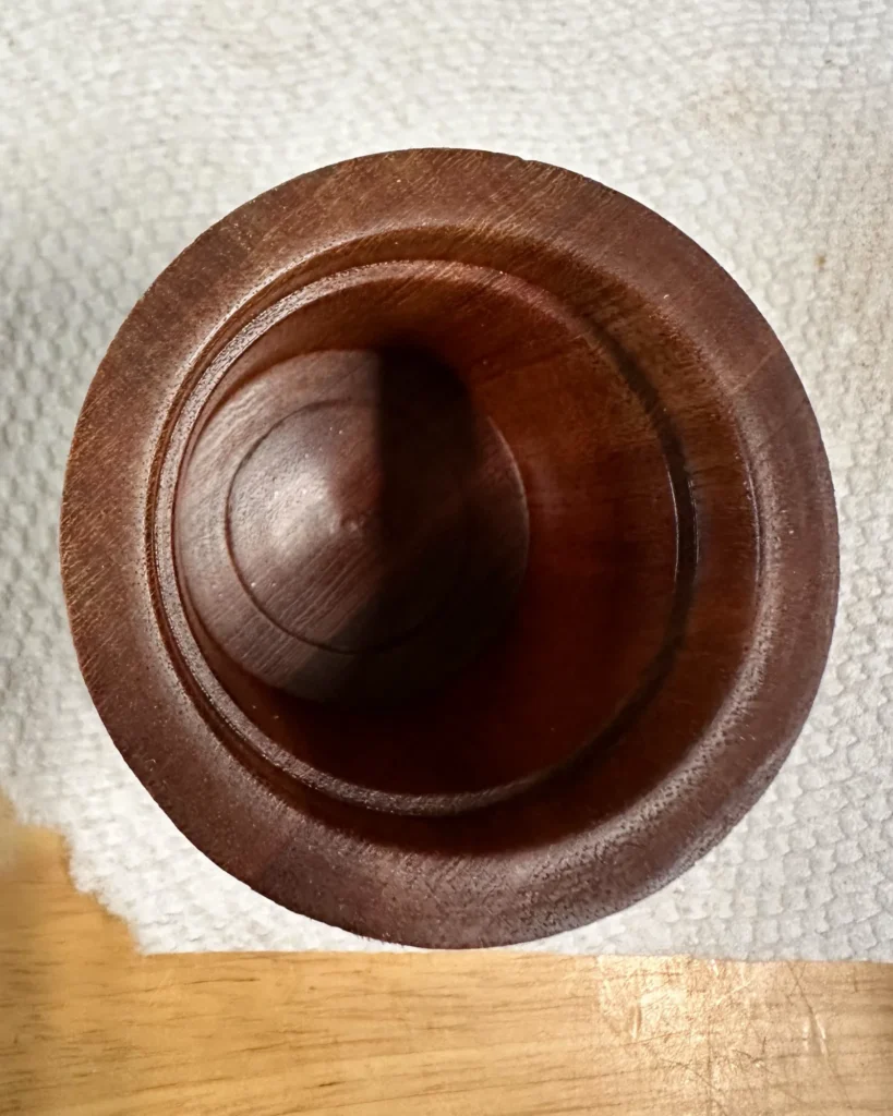 View into the hollowed Sipo mahogany box, showing the smooth interior and stepped rim around the opening.