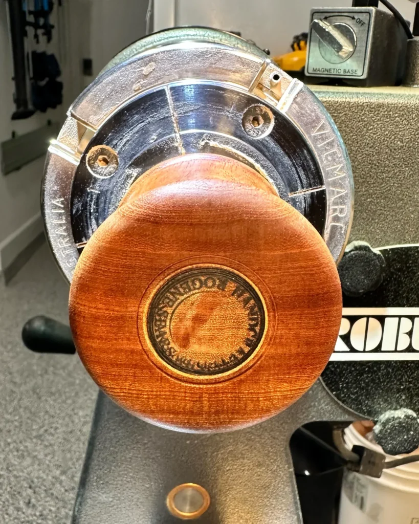 Finished underside of Inner Sanctuary on the lathe, with a circular Chipin’ Wood maker’s mark at the center.