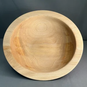 nterior view of a sycamore bowl showing curved grain patterns and pale cream and honey-colored wood.