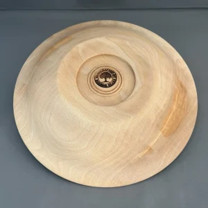 Underside of a sycamore wood bowl showing its recessed circular base, maker’s mark, and natural grain.
