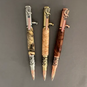 Three wooden Statue of Liberty bolt-action pens arranged horizontally with copper, brass, and pewter-colored hardware.